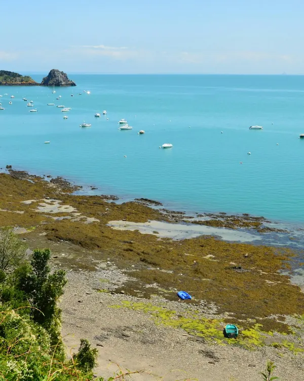 La baie de Cancale à marée montante : eau turquoise, bateaux au mouillage et rochers au loin